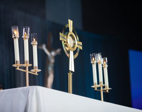 a table topped with candles and a cross on top of it